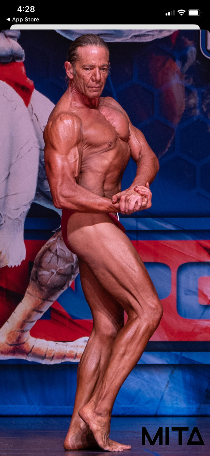Bodybuilder posing during a competition on stage.