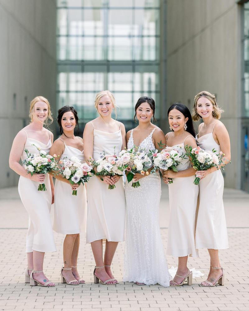 Cheers to Birdy 👰🏻♀️ Olivia & her crew in our Lisa Satin Midi in Champagne 🥂🥂🥂 • PS, Lisa in Champagne is currently sold out… but we are bringing her BACK in Gold, Rose Gold, Taupe, Terracotta and Dark Mauve later this fall (ships Feb 2022) in a newer, shinier & more luxe satin fabric so stay tuned for details 😘 • 📸: @angiescottphotography #birdyinthewild #BIRDYGREY