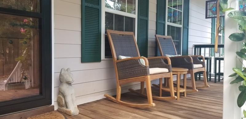 A Lush Tree Canopy Inspires A Timber Merchant's Own Mod Home Outdoor  seating group of teak furniture, tall stand of trees in the background -  Luxe Interiors + Design