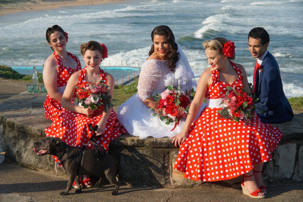 Bride wears tea-length white wedding dress with red, purple polka